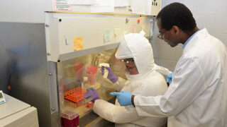 Virologist Kouacou Konan, PhD, right, and lab manager Greg Hurteau, of the Department of Immunology