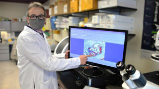 Antonio Paul, PhD, pointing at results on a computer monitor