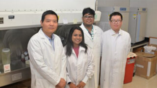 Dr. Wei Sun and his team standing for a photo in his lab