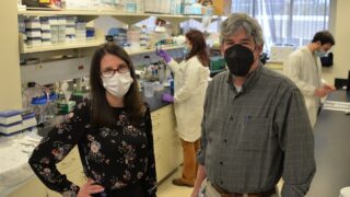 Researchers Kristen Zuloaga, PhD, and Kevin Pumiglia, PhD, in the lab