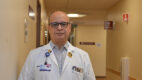 Doctor wearing a white coat standing in a clinic hallway