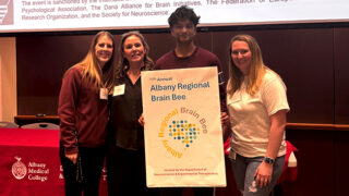 Sam Vadivelu, winner of the 2026 Albany Regional Brain Bee, standing with three members of Albany Regional Brain Bee Committee