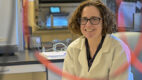 Research scientist Gabrielle Fredman, PhD, in her lab wearing a white coat