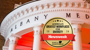 Albany Medical Center Hospital's pillars entrance overlaid with a graphic from Newsweek citing the medical center as one of America's greatest workplaces for diversity.