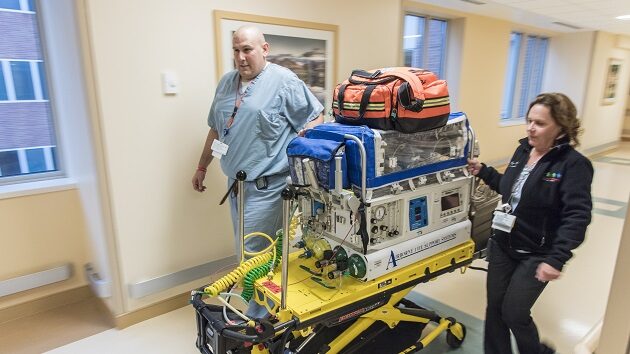 Two health care workers doing an emergency transfer of a NICU baby