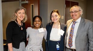 A group of four people posing at an event