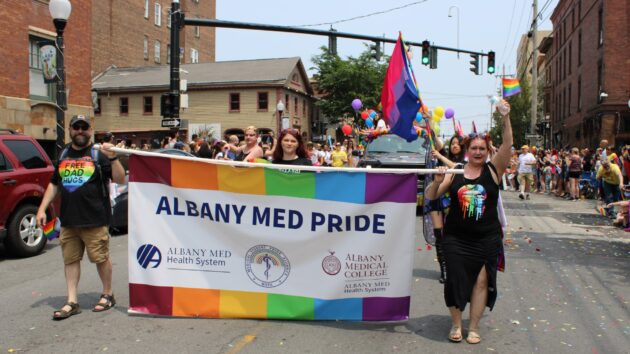 Participants in the June 2023 Capital Pride Parade hold a banner that reads Albany Med Pride.