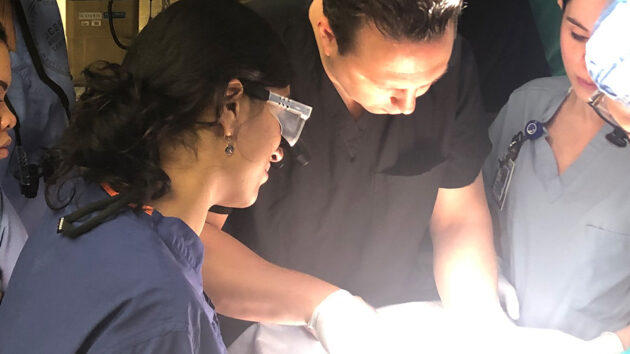 Medical students watch a surgeon perform a procedure