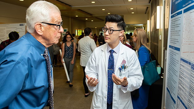 A student discusses their work at Medical Student Investigation Day