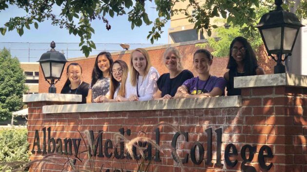 Students of the NextGen Neuroscience Summer Program standing by the Albany Medical College sign