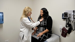 Doctor using stethoscope to examine patient