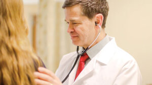 Doctor using stethoscope to examine patient