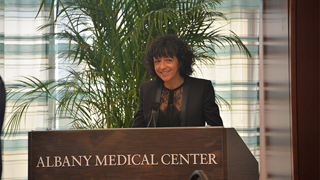 A recipient of the Albany Prize stands at a podium