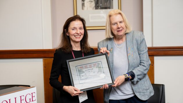 A woman accepts an award from another woman at the Alumni Association Reunion.