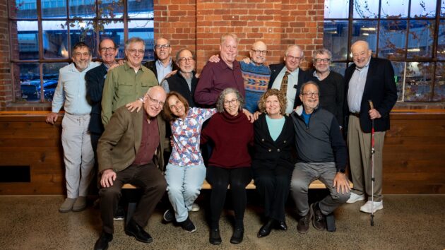 A large group of people gathering for a class photo at their class reunion.