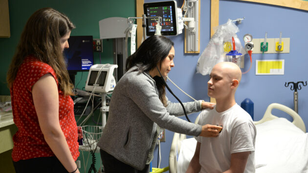 A peds resident takes a patient's vitals