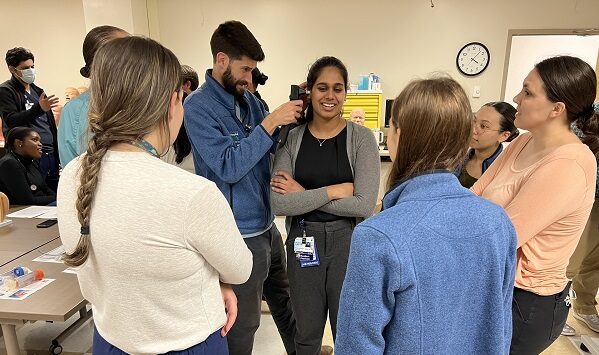 Pediatric residents practice listening to someone's ears